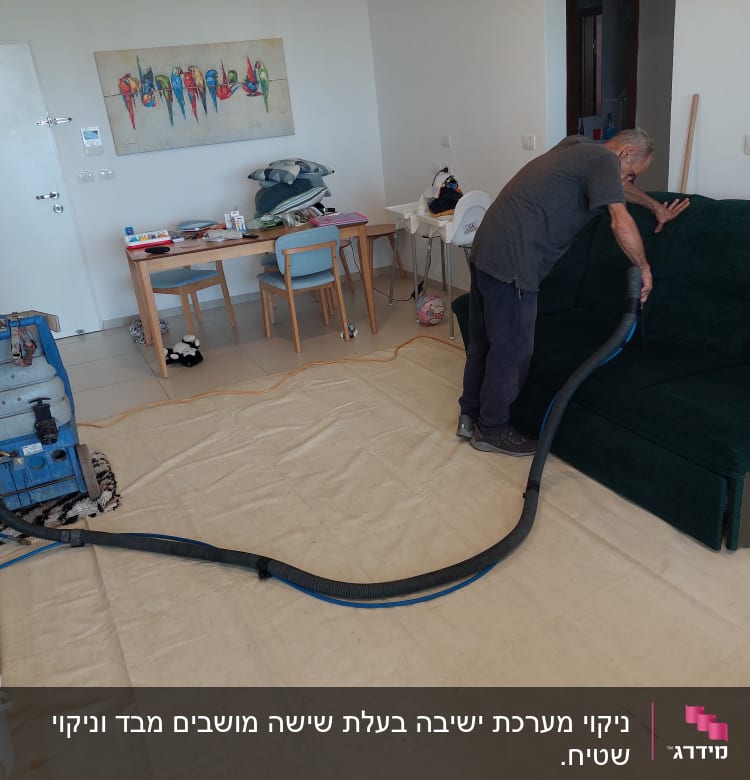 אדם מנקה ספה עם מכונת ניקוי מקצועית
